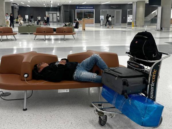 Un pasajero duerme en un pasillo del aeropuerto internacional George Bush, en Houston (Estados Unidos).