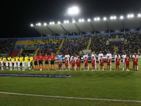 Ambas plantillas ya realizan el protocolo para el inicio del partido.