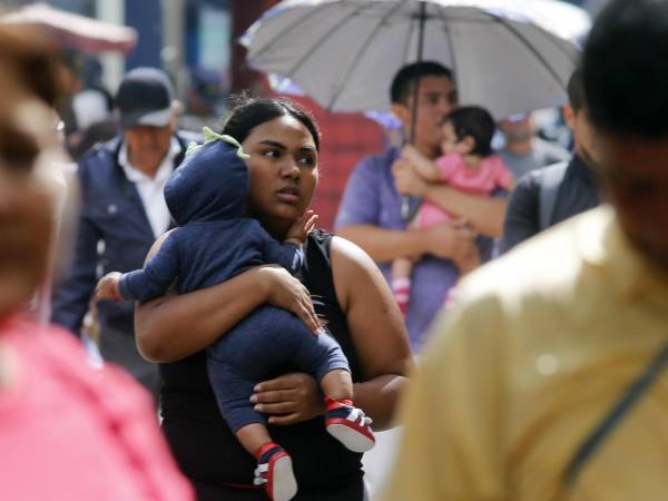 Una mujer sostiene un bebe en brazos en la Plaza Central de Tegucigalpa este viernes, en Tegucigalpa (Honduras).