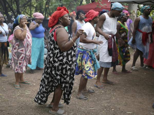 Mujeres garífunas participan en un baile tradicional de su cultura en un campamento instalado frente a la sede de la Corte Suprema de Justicia, este jueves en Tegucigalpa (Honduras).