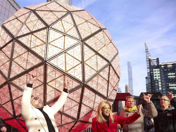 El cantante Pitbull, la fundadora de CleanBoss Joy Mangano y el presidente de Jamestown, Michael Phillips, reaccionan al encender la bola después de limpiar la bola de cristal de Nochevieja en lo alto de One Times Square en Nueva York, Nueva York, EE. UU.