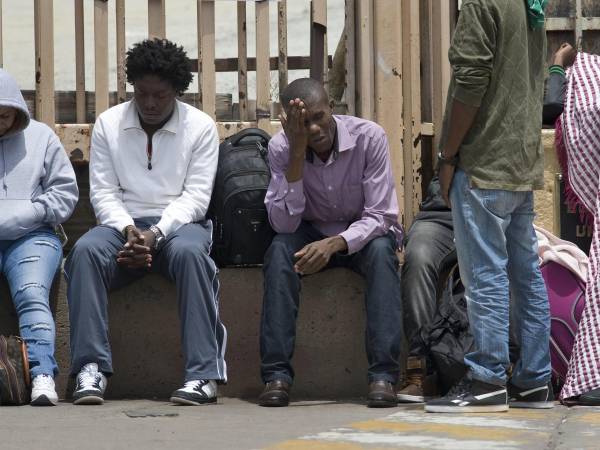 Fotografía de archivo en donde se observa a inmigrantes esperando en la frontera entre México y Estados Unidos. EFE/DAVID MAUNG