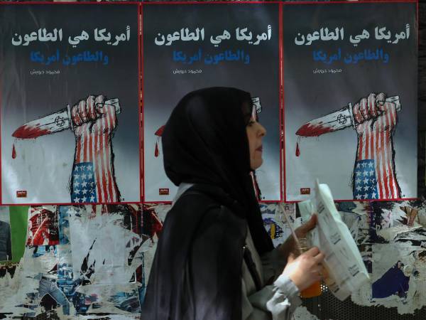 Una mujer pasa junto a carteles políticos colgados en la pared en una calle de Beirut, Líbano, 09 de junio de 2026. EFE/EPA/WAEL HAMZEH
