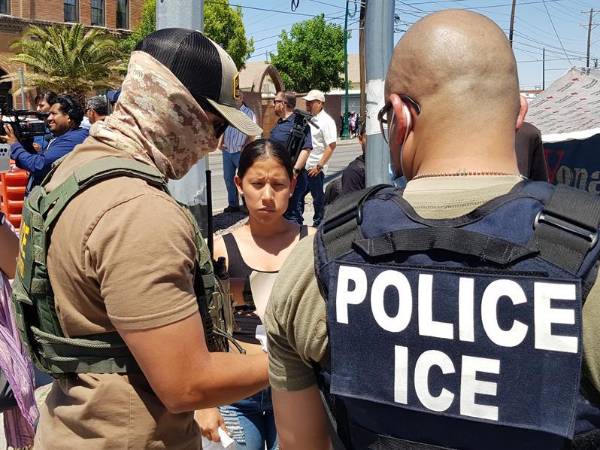 Un agente de la Patrulla Fronteriza y uno del Servicio de Control de Inmigración y Aduanas revisan los papeles de una inmigrante indocumentada en la ciudad fronteriza de El Paso, Texas (EEUU).