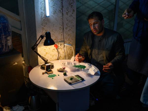 Rahmatullah Sharifi, un comerciante, pesa esmeraldas. No le importa pagar impuestos por sus compras en subastas, dijo. (Elise Blanchard para The New York Times)