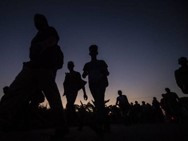 Migrantes caminan por un desierto en busca de llegar a Estados Unidos.