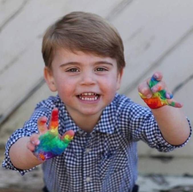 En las imágenes al quinto en la línea al trono británico sonriendo para la cámara con las manos cubiertas de pintura multicolor justo antes de estamparlas en una hoja en blanco.<br/>