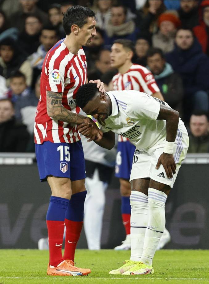 El defensa montenegrino Stefan Savić le ayuda a levantarse a Vinicius tras una jugada entre ambos.