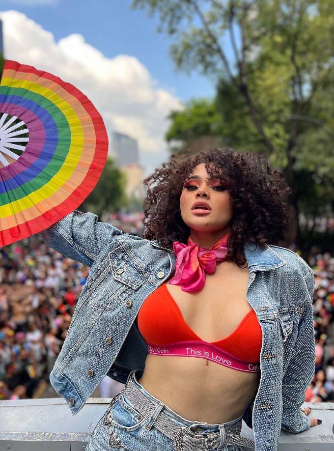 ”Tirenme una caguama” dijo la joven hondureña entre risas y sosteniendo un abanico de colores del arcoiris representativo del Orgullo.