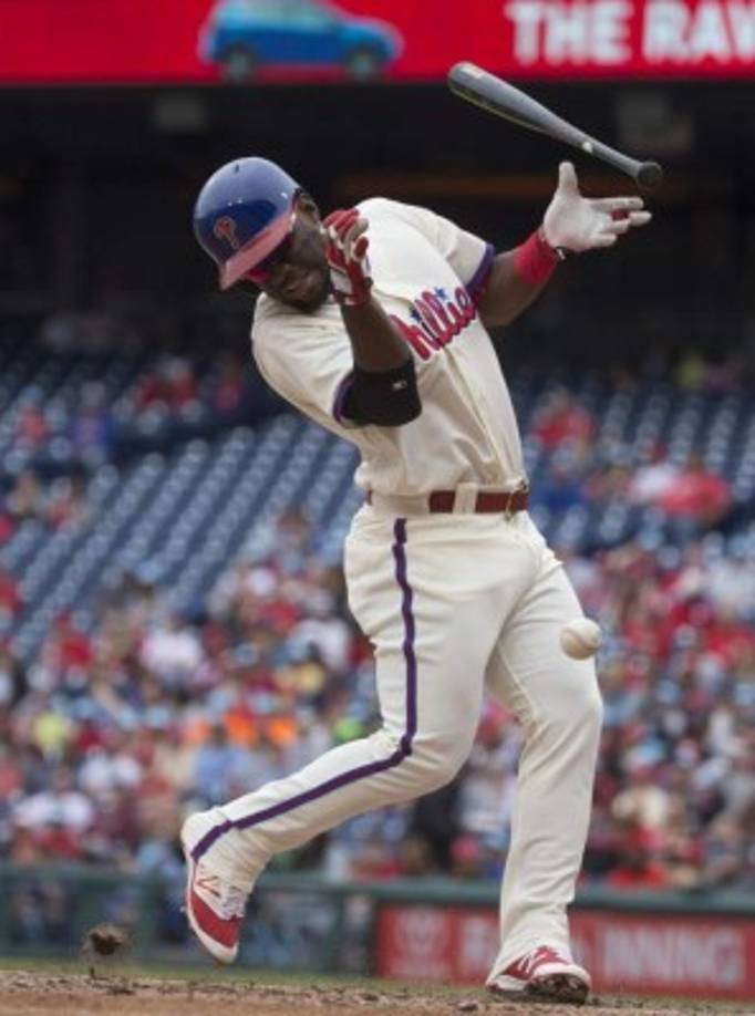Odubel Herrera, de los Phillies de Filadelfia, es golpeado por un lanzamiento en juego contra los Bravos de Atlanta en el parque de Filadelfia.
