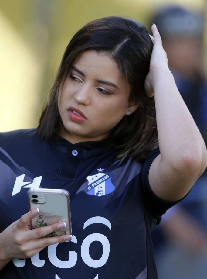 Esta chica progreseña se distrajo con el celular antes del inicio del partido en el Micheletti.