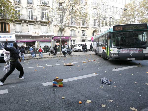 Varias personas lanzan piedras contra un autobús en París el pasado sábado en los disturbios registrados en el país. EFE/Lucas Dolega