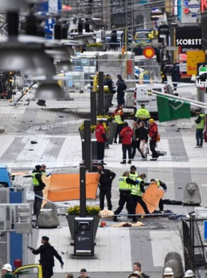 Los servicios de emergencia atienden a las víctimas y limpian los destrozos dejados por el ataque terrorista de Estocolmo.