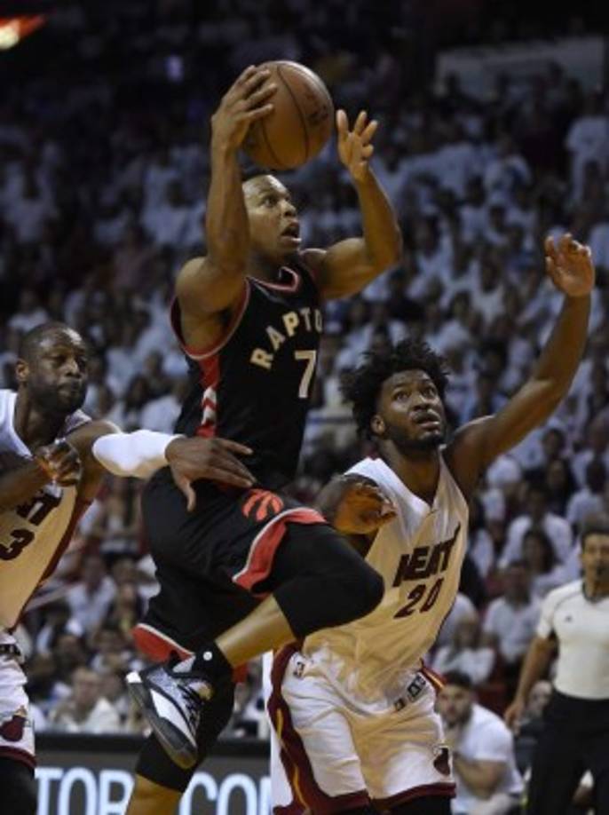 Dwyane Wade (izquierda) y Justise Winslow (derecha), de Heat, ante Kyle Lowry (centro), de Raptors, en la semifinal de la Conferencia Este. FOTO EFE/RHONA WISE/