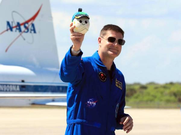 Especialista de misión de Artemis II, Jeremy Hansen, de la Agencia Espacial Canadiense (CSA), sosteniendo Rise, la mascota lunar e indicador de gravedad cero para el vuelo de prueba alrededor de la luna.