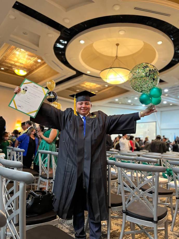 Bayron José Espinal Núñez muestra orgulloso el título obtenido en la UTH.