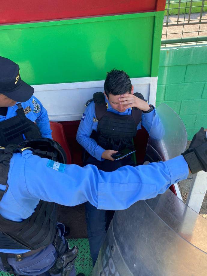Policía Nacional viendo el encuentro por el celular.