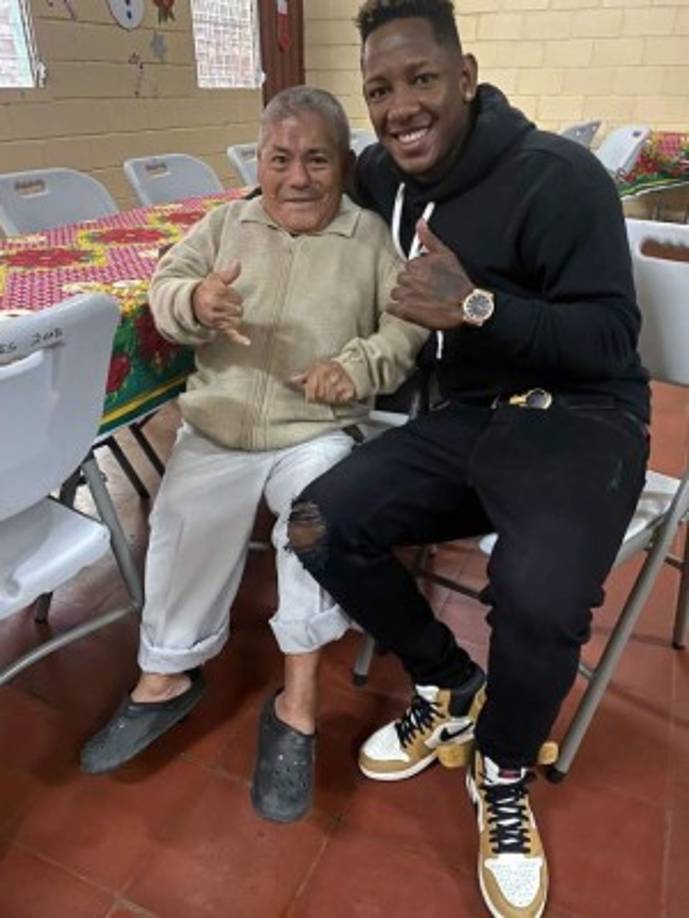 Romell Quioto sonriendo con un anciano para una foto.