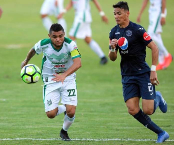 El paraguayo del Motagua, Roberto Moreira, va a la disputa del balón con Alexander Aguilar del Platense.