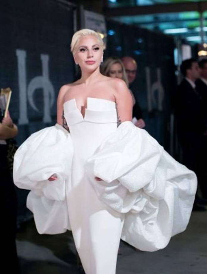 Cabello rubio y un atuendo elegante blanco.