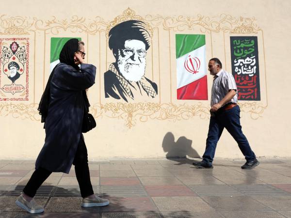 Iraníes caminan junto a un mural del difunto líder supremo iraní, el ayatolá Alí Jameneí, en el centro de Teherán, Irán, el 13 de septiembre de 2026. EFE/EPA/