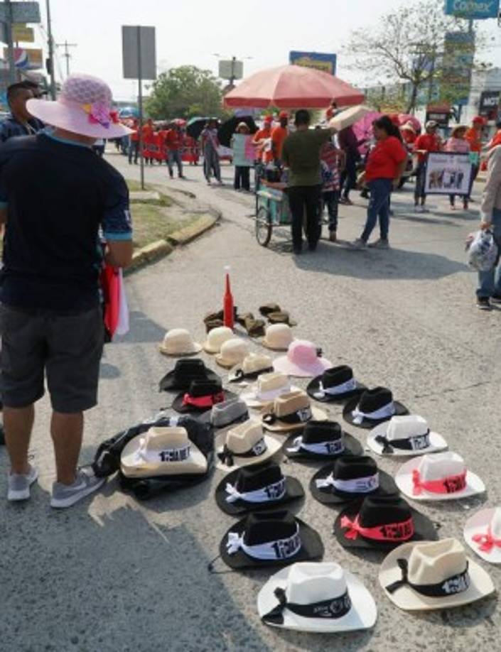 Para protegerse del sol, esta mujer aprovechó para vender sombreros con el logo de 1 de Mayo.