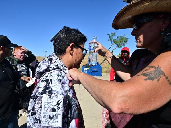 Activistas estadounidenses llevan agua a los migrantes que esperan en la frontera para poder cruzar en Arizona.