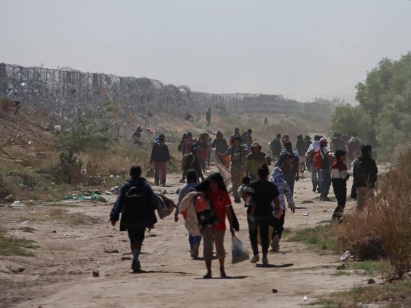 Migrantes caminan entre las fronteras de México con Estados Unidos este miércoles en Ciudad Juárez, Chihuahua.