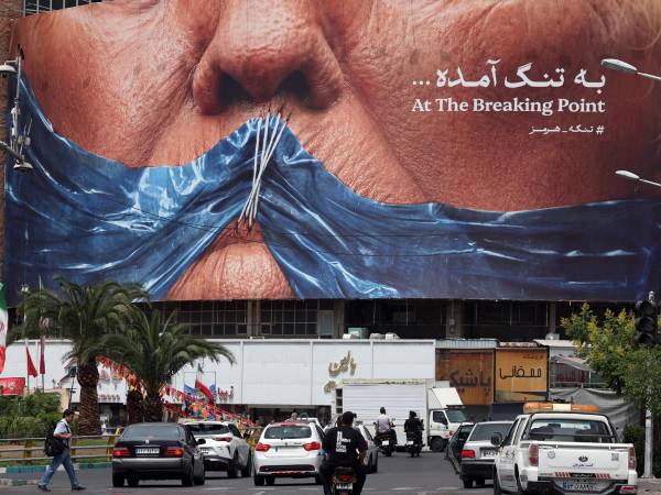 Iraníes conducen frente a un gran cartel antiestadounidense que muestra al presidente estadounidense Donald Trump y el estrecho de Ormuz en la plaza Valiasr en Teherán, Irán, el 28 de mayo de 2026. EFE/EPA/ABEDIN TAHERKENAREH RESTRICTIONS