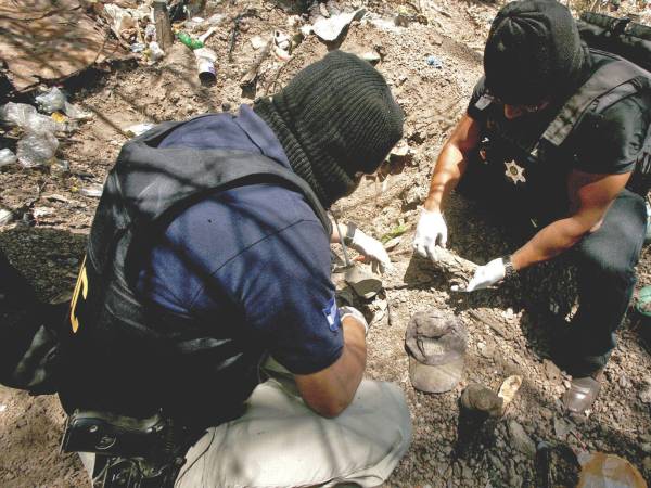 Equipos especializados encontraron diversas ropas al abrir las fosas en terreno cercano a las viviendas en Lomas del Carmen.