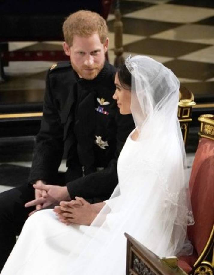 El príncipe Harry, Duque de Sussex (L) de Gran Bretaña se sienta con la actriz estadounidense Meghan Markle (R) durante la lectura en la Capilla de San Jorge, en Windsor Castle, en Windsor, el 19 de mayo de 2018 durante su ceremonia de boda.<br/>Owen Humphreys / PISCINA / AFP
