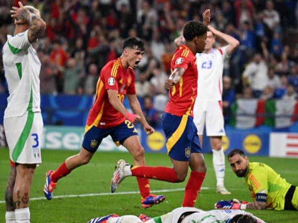 Jugadores de España celebran el gol de la victoria ante el lamento de los italianos.