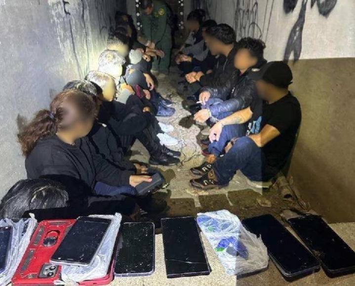 Un grupo de migrantes detenidos por las autoridades fronterizas tras ser hallados ocultos en alcantarillas.