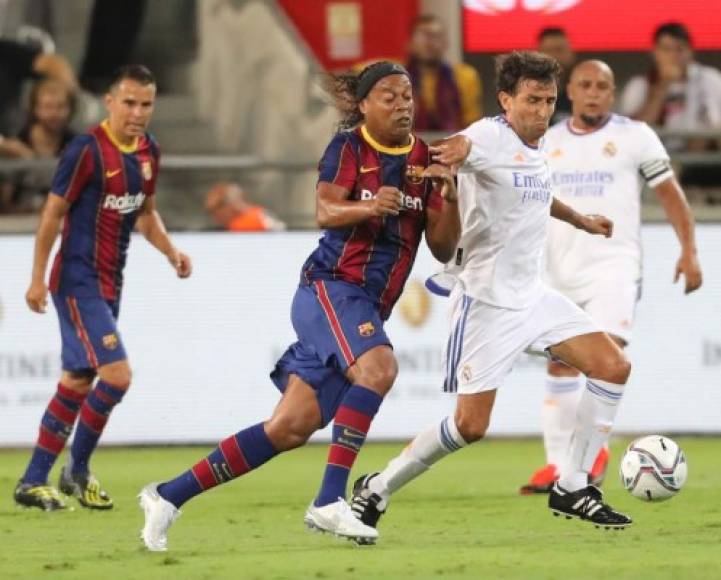 Ronaldinho luchando por el balón con Luis Milla.