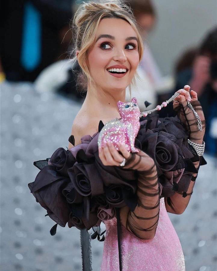 Chloe Fineman mostrando su bolso rosa en forma de gato.