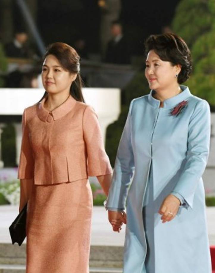 La esposa de Kim, Ri Sol-ju tomada de la mano de Kim Jung-Sook.