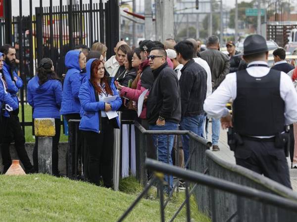 Ciudadanos colombianos solicitantes de visa de los Estados Unidos esperan en una fila en la sede de la embajada de EEUU en Bogotá (Colombia).