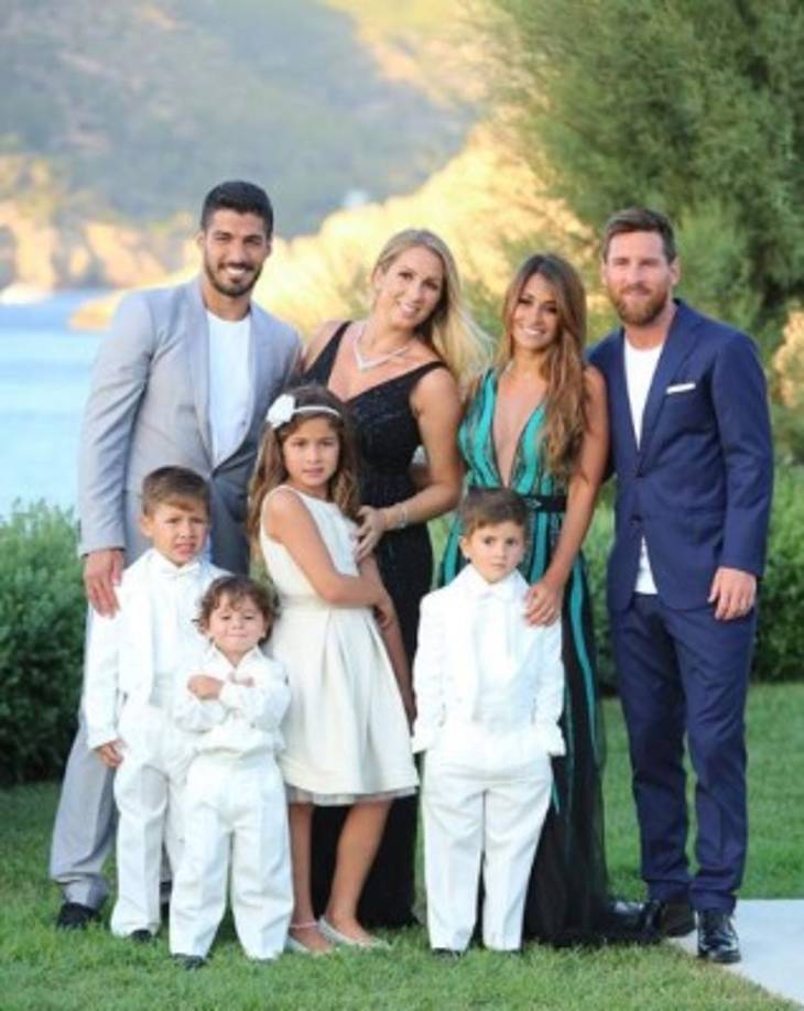 Leo Messi y Luis Suárez posando junto a sus familias.
