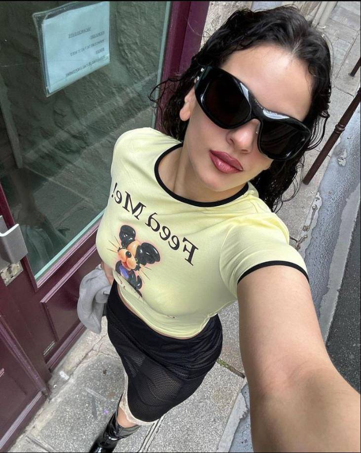 La cantante posó con un look de playera amarilla neón donde se alcanza a leer la frase ‘Feed Me’, (aliméntame en español) y el estampado de un perrito ¿Quiso decirnos algo? a su vez, combinaba con una falda de transparencias negra, con un detalle de encaje blanco y unas botas de charol características de la ‘Motomami’.