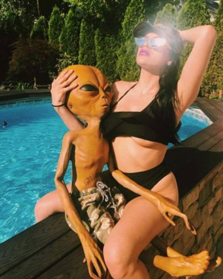 El 'marcianito' posa con una sexy mujer en la piscina.