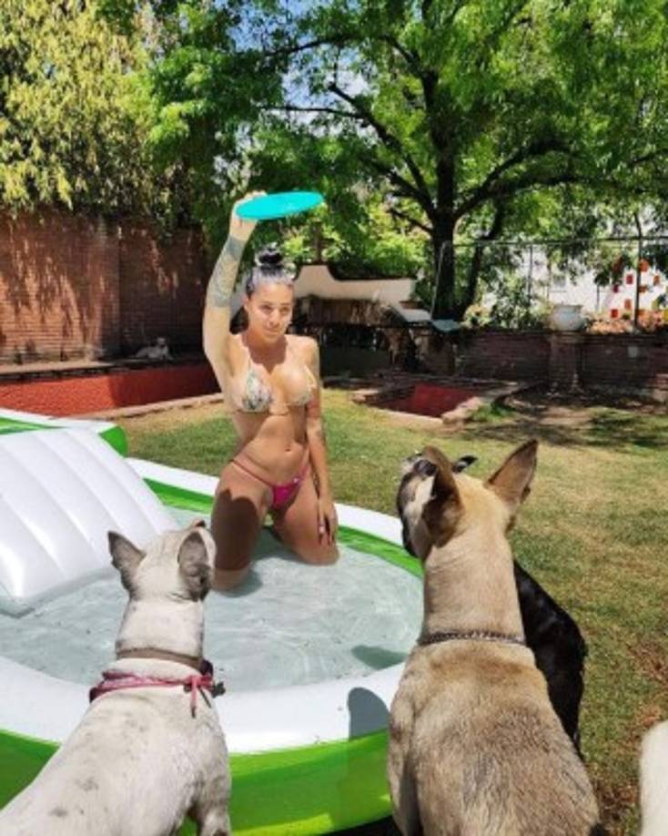 En un diminuto bikini, floreado de la parte de arriba y en color rosa de abajo, la colombiana compartió unas imágenes en las que se le ve en una alberca, lista para lanzarles un frisbee a los tres perritos que la acompañaban, quienes esperaban sentados el momento de lanzarse por él.