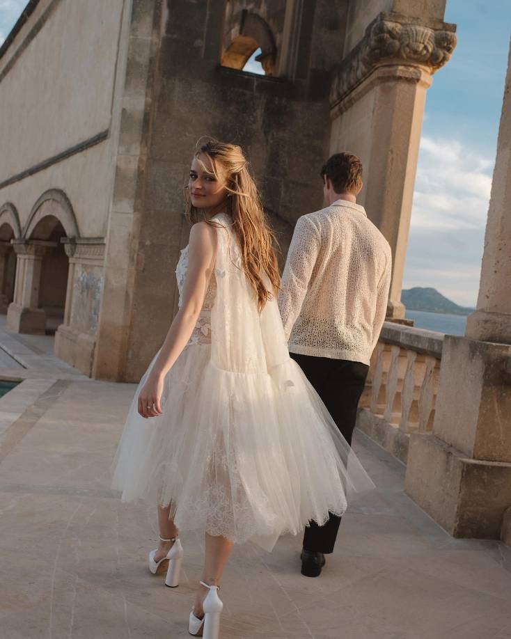 Para la recepción usó un vestido de la colección Primavera 2021 “Faille Vine Halter” y para la cena, uno perteneciente a la colección Primavera de 2022 “Cape Cocktail”. Ambos con un diseño que se distinguía por las transparencias, flores bordadas y tul.