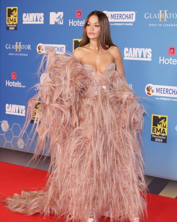 Si hay una reina de las alfombras rojas en estos premios europeos de la música es Rita Ora, presentadora de la gala por tercera vez y que después de conseguir la atención de todos los focos con su famoso ‘outfit’ de albornoz en Londres 2017, regresó a la red carpet de Mánchester con un extravangante vestido de plumas artificiales de Ashi Studio.