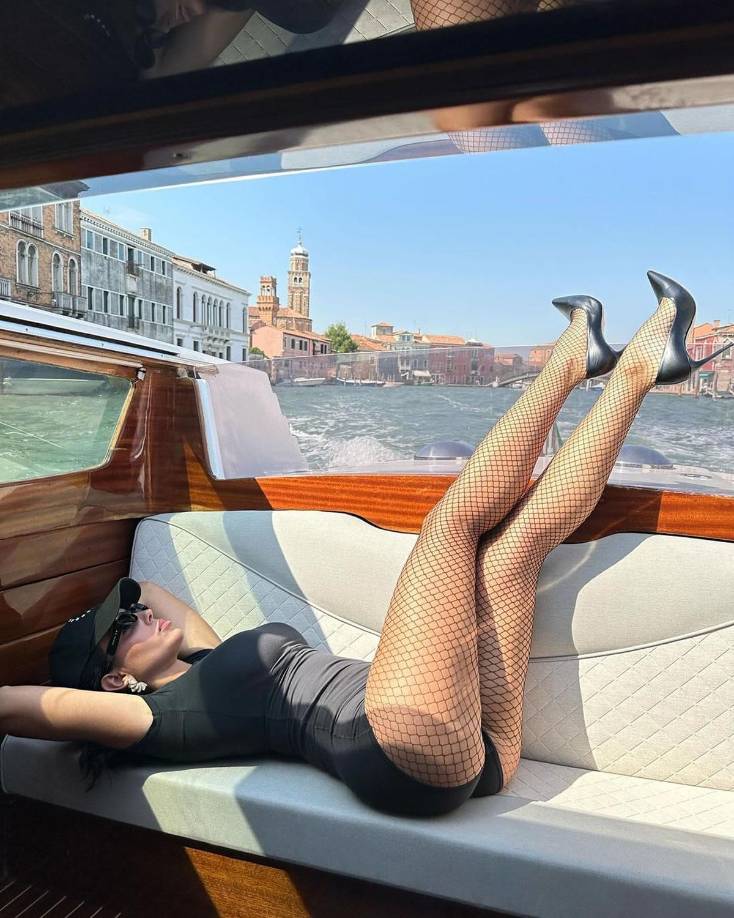 Sentada en la parte trasera de un taxi acuático, la pareja de Cristiano Ronaldo pataleaba en el aire con sus largas piernas, mostrando sus seductoras medias de rejilla.