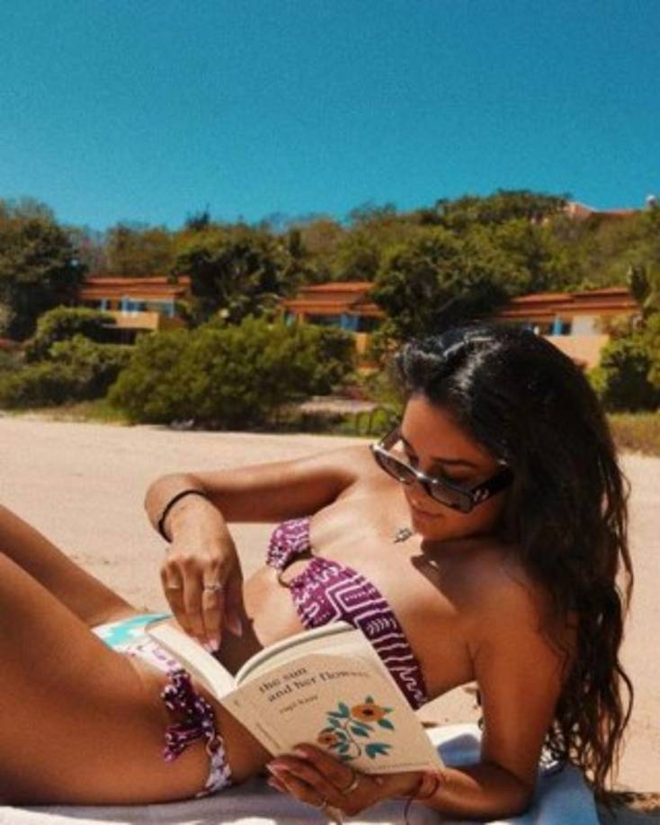 La chica posó en un bikini de dos piezas mientras disfruta del sol y lee el libro 'The sun and her flowers' (El sol y sus flores).