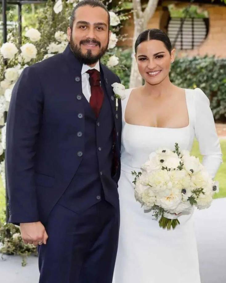 La pareja se casó el 8 de octubre en una boda civil , pero para la boda del sábado ella usó un vestido de manga larga y cuerpo bordado con pedrería, combinado con una falda de tul con una amplia abertura lateral que dejaba su pierna al descubierto. Él eligió un traje de estilo militar en color azul marino a juego con el chaleco y una corbata vino de Burdeos.