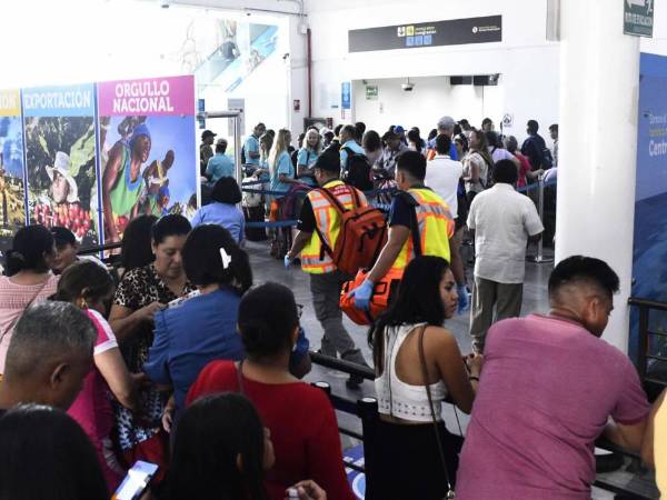 Viajeros esperan turno para abordar en una de las terminales del aeropuerto Ramón Villeda Morales.