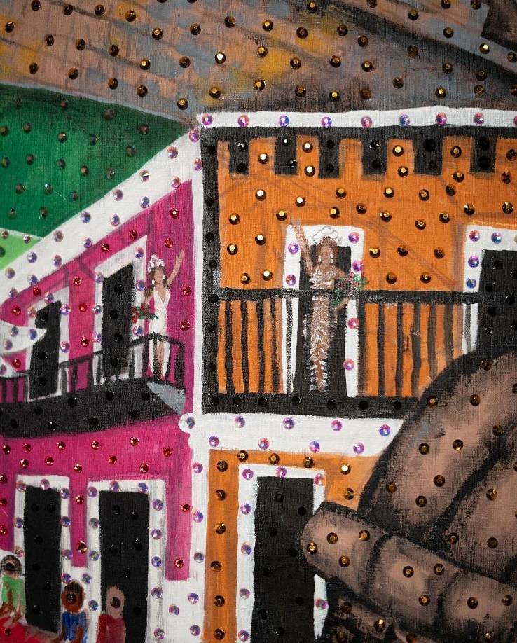 En la parte posterior del vestuario, una pintura a mano ofrece una vista panorámica del Castillo San Felipe del Morro, los cabezudos, vigilantes, y bailarines folclóricos que danzan sobre la multitud festiva, con la bandera Monoestrellada ondeando en lo alto. 