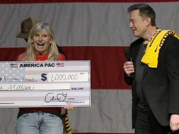 Musk junto a una de las cuatro personas que han ganado su lotería de un millón de dólares.