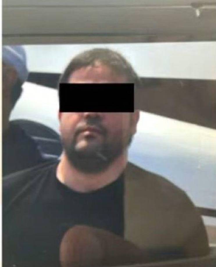 Por su parte, la foto de Joaquín Guzmán López lo muestra con abundante barba y escoltado en lo que parece ser una pista de aterrizaje. Al momento de su detención, portaba una playera negra.